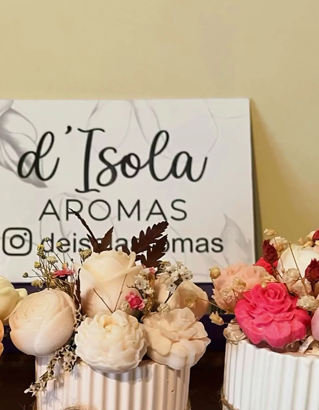 Mesa de d'Isola con bouquets y el cartel de la marca