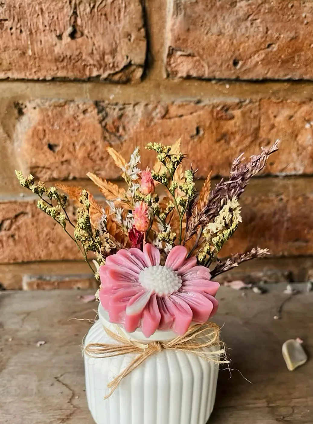 Maceta de yeso con margarita rosa y flores secas