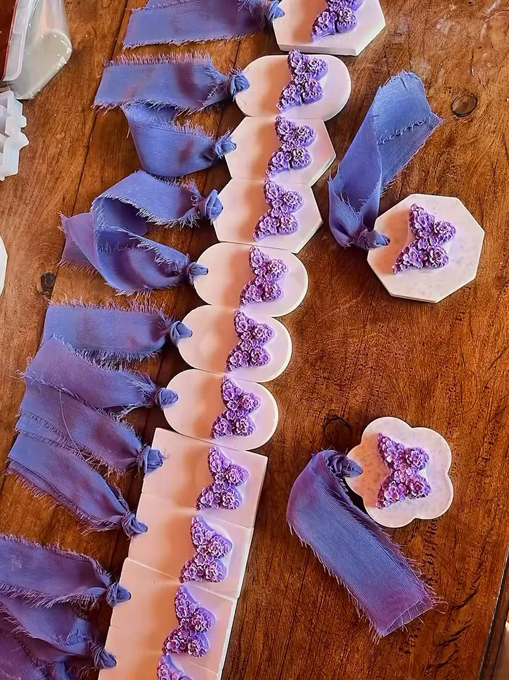 Souvenirs de cera con mariposas lilas y cintas de gasa