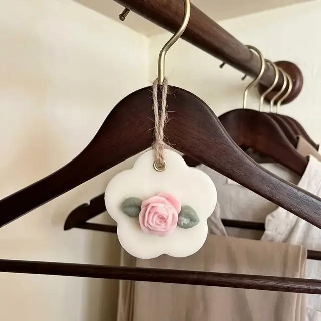 Wax tablet con forma de flor y una rosa de cera, colgada de una percha